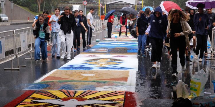 Fiéis enfrentam chuva para confeccionar tapetes de Corpus Christi no Rio